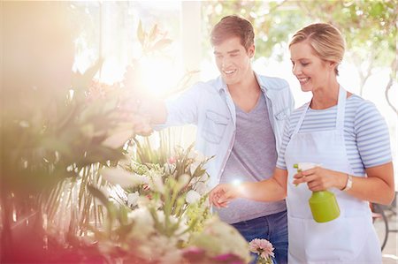 Florist spraying flowers with water bottle in flower shop Stock Photo - Premium Royalty-Free, Code: 6113-08536219