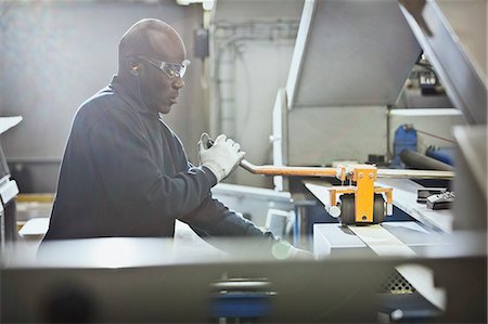 Worker operating machinery in steel factory Photographie de stock - Premium Libres de Droits, Code: 6113-08655284