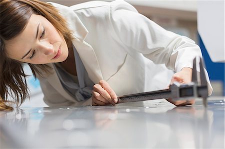 Engineer with calipers measuring sheet metal in steel factory Stock Photo - Premium Royalty-Free, Code: 6113-08655297