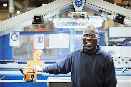 portraits of everyday people - Portrait smiling worker at machine in steel factory Stock Photo - Premium Royalty-Free, Code: 6113-08655226