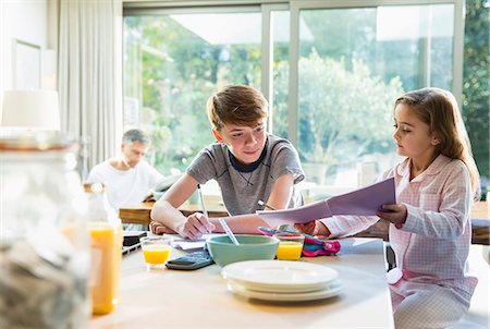 pyjamas family - Brother and sister eating breakfast and doing homework Stock Photo - Premium Royalty-Free, Code: 6113-08655374