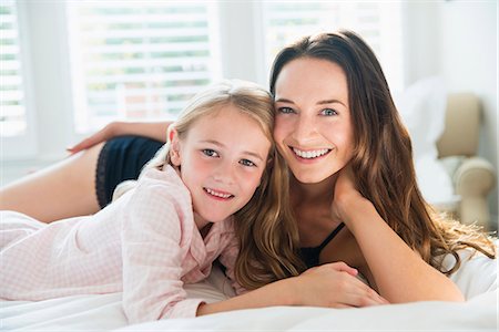 simsearch:6113-07731678,k - Portrait smiling mother and daughter laying on bed Photographie de stock - Premium Libres de Droits, Code: 6113-08655380