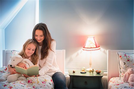 Mother and daughter reading book in bedroom Stock Photo - Premium Royalty-Free, Code: 6113-08655386