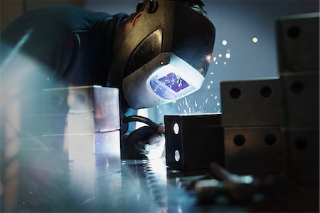 simsearch:6113-08655350,k - Welder using welding torch on steel in steel factory Photographie de stock - Premium Libres de Droits, Code: 6113-08655331