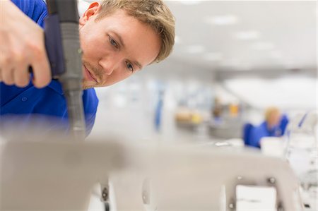 simsearch:6113-08655241,k - Focused worker using drill in steel factory Stock Photo - Premium Royalty-Free, Code: 6113-08655336