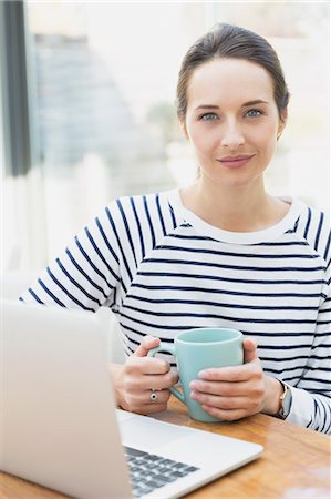 simsearch:6113-07542825,k - Portrait confident woman drinking coffee at laptop Stock Photo - Premium Royalty-Free, Code: 6113-08655458