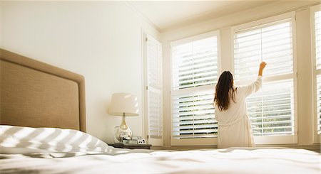 store - Woman in bathrobe opening bedroom window blinds Photographie de stock - Premium Libres de Droits, Code: 6113-08655477