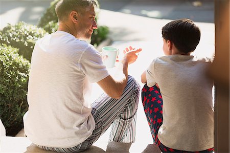 Father with coffee talking to son on front stoop Foto de stock - Sin royalties Premium, Código: 6113-08655404