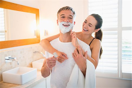 simsearch:6113-08655424,k - Playful wife wiping shaving cream on husband's face in bathroom Foto de stock - Sin royalties Premium, Código: 6113-08655437