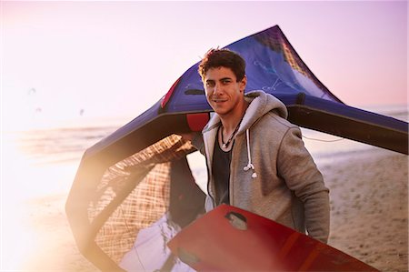 summer sport - Portrait confident man carrying kiteboard equipment on beach Photographie de stock - Premium Libres de Droits, Code: 6113-08655545