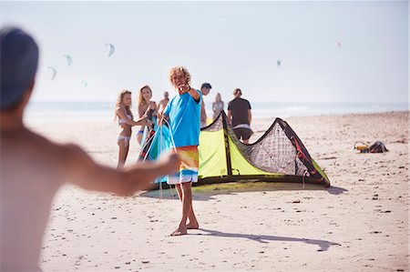 Friends preparing kiteboarding kite on sunny beach Stock Photo - Premium Royalty-Free, Code: 6113-08655549