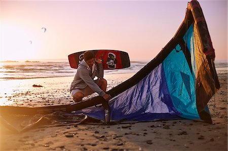 Man with kiteboarding equipment on sunset beach Stock Photo - Premium Royalty-Free, Code: 6113-08655552