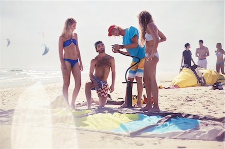 pumping - Friends preparing kiteboarding kite on sunny beach Stock Photo - Premium Royalty-Free, Code: 6113-08655572