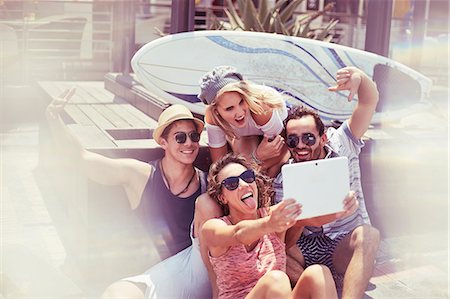 simsearch:614-06624998,k - Playful young friends taking selfie in front of surfboard with digital tablet Photographie de stock - Premium Libres de Droits, Code: 6113-08655579