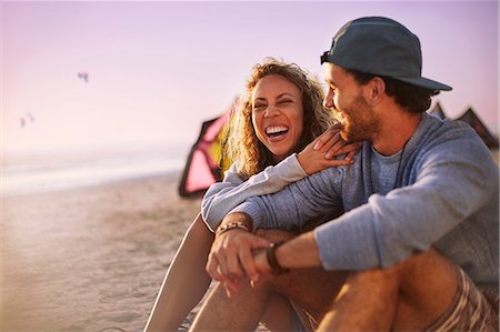 Laughing couple sitting on beach Stock Photo - Premium Royalty-Free, Code: 6113-08655516