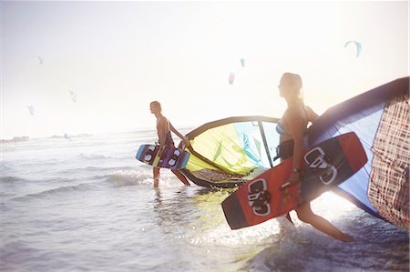 summer sport - Couple walking into surf with kiteboard equipment Photographie de stock - Premium Libres de Droits, Code: 6113-08655528