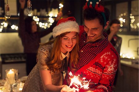 présent - Playful couple with Christmas sparklers Stock Photo - Premium Royalty-Free, Code: 6113-08659564