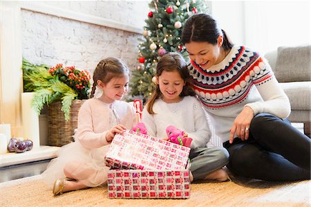 simsearch:649-08894373,k - Mother and daughters opening Christmas gifts on living room floor Stock Photo - Premium Royalty-Free, Code: 6113-08659595