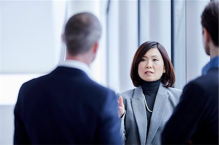 simsearch:6113-07159058,k - Businesswoman talking to colleagues Stock Photo - Premium Royalty-Free, Code: 6113-08659650