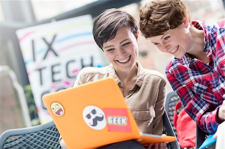 simsearch:6113-08698001,k - Smiling women using laptop at technology conference Photographie de stock - Premium Libres de Droits, Code: 6113-08697996