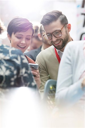 simsearch:6113-08805879,k - Smiling business people texting at technology conference Stock Photo - Premium Royalty-Free, Code: 6113-08697999