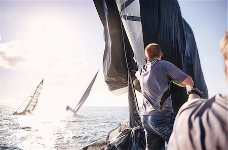 Man sailing on sunny ocean Photographie de stock - Premium Libres de Droits, Code: 6113-08698091