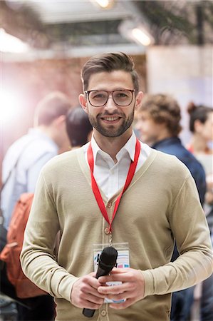 radiodifusão - Portrait smiling speaker with microphone at technology conference Foto de stock - Royalty Free Premium, Número: 6113-08698012