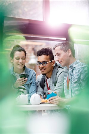 Men and women texting with cell phone in cafeteria Photographie de stock - Premium Libres de Droits, Code: 6113-08698038