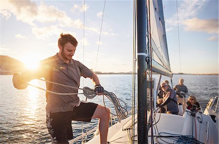 Man sailing looping rigging on sailboat Photographie de stock - Premium Libres de Droits, Code: 6113-08698145