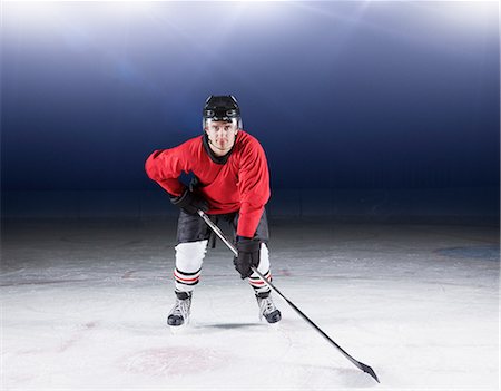 Portrait determined hockey player in red uniform on ice Stock Photo - Premium Royalty-Free, Code: 6113-08698158