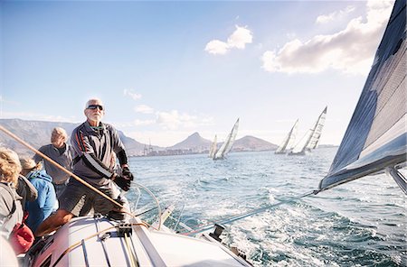 retirement outdoors - Man adjusting sailboat rigging on sunny ocean Stock Photo - Premium Royalty-Free, Code: 6113-08698110