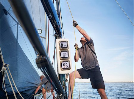 Man adjusting sailing equipment on sailboat Stock Photo - Premium Royalty-Free, Code: 6113-08698133