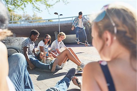 simsearch:6113-08698253,k - Teenage friends hanging out skateboarding at sunny skate park Photographie de stock - Premium Libres de Droits, Code: 6113-08698259