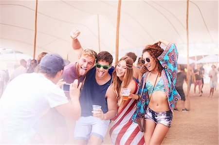 Playful young friends with beer posing for camera phone at music festival Stock Photo - Premium Royalty-Free, Code: 6113-08698269
