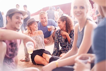 Young friends hanging out drinking beer and talking at music festival Photographie de stock - Premium Libres de Droits, Code: 6113-08698275