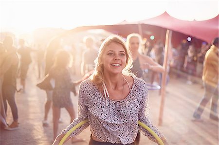 flare - Smiling young woman with plastic hoop at music festival Stock Photo - Premium Royalty-Free, Code: 6113-08698285