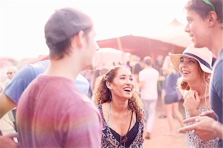 simsearch:6113-08105413,k - Young friends hanging out talking at music festival Foto de stock - Royalty Free Premium, Número: 6113-08698298