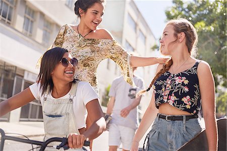 simsearch:6113-08698253,k - Teenage girls with BMX bicycle and skateboard on sunny urban street Photographie de stock - Premium Libres de Droits, Code: 6113-08698239