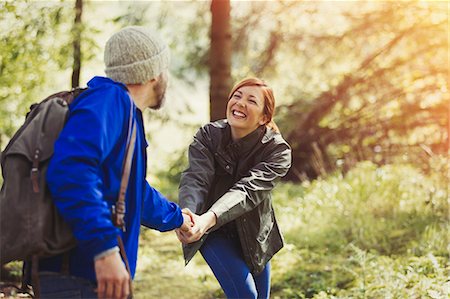 Smiling couple holding hands hiking in woods Stock Photo - Premium Royalty-Free, Code: 6113-08743441