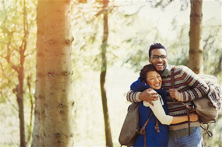 simsearch:6113-07542558,k - Playful couple with backpacks hugging hiking in woods Stock Photo - Premium Royalty-Free, Code: 6113-08743452