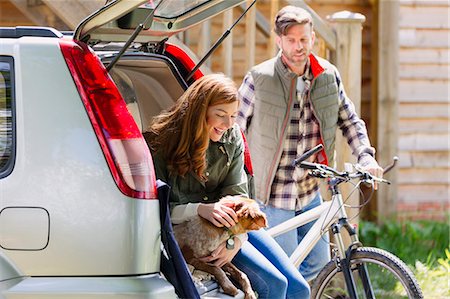 Couple with dog and mountain bike at back of car outside cabin Photographie de stock - Premium Libres de Droits, Code: 6113-08743493