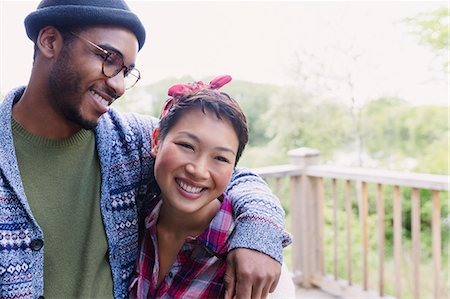 Smiling couple hugging on deck Stock Photo - Premium Royalty-Free, Code: 6113-08743498