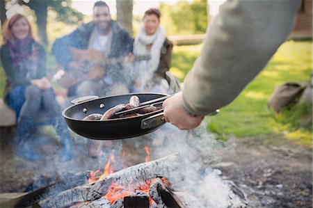 simsearch:640-03260329,k - Man cooking hot dogs over campfire for friends Stockbilder - Premium RF Lizenzfrei, Bildnummer: 6113-08743549