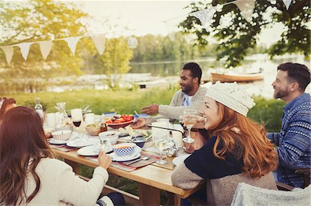 Friends enjoying lunch at lakeside patio table Photographie de stock - Premium Libres de Droits, Code: 6113-08743579