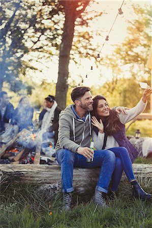 simsearch:6113-08927968,k - Couple posing for selfie with camera phone near campfire Fotografie stock - Premium Royalty-Free, Codice: 6113-08743587