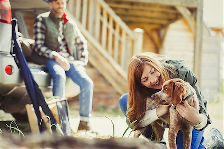 dog road trip - Woman petting dog outside cabin Stock Photo - Premium Royalty-Free, Code: 6113-08743523