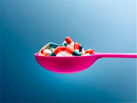 simsearch:614-03577280,k - Medicine capsules in pink spoon against blue background Stock Photo - Premium Royalty-Free, Code: 6113-08743667