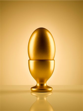 egg and nobody - Golden egg in egg cup holder against gold background Stock Photo - Premium Royalty-Free, Code: 6113-08743668