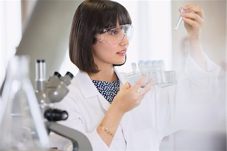 Female college student conducting scientific experiment examining vials in science laboratory classroom Photographie de stock - Premium Libres de Droits, Code: 6113-08769657