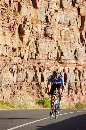 simsearch:6113-07588701,k - Male triathlete cyclist cycling on sunny road Stock Photo - Premium Royalty-Free, Code: 6113-08769762